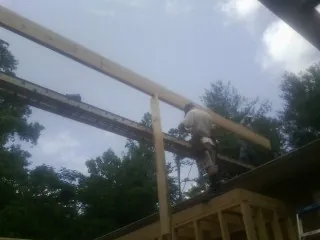 Carpenter setting a ridge beam over a new addition frame — Ice Dam Removal by Roofing Brothers in Almond