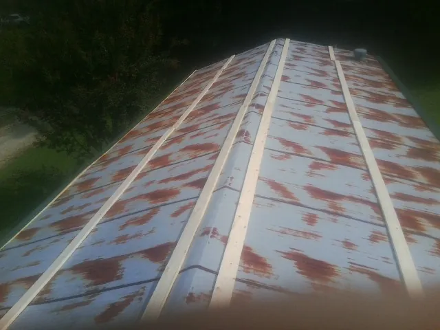 Rusted metal roof panels with new wood purlins before replacement — Storm Damage Roof Repair in Almond by Roofing Brothers