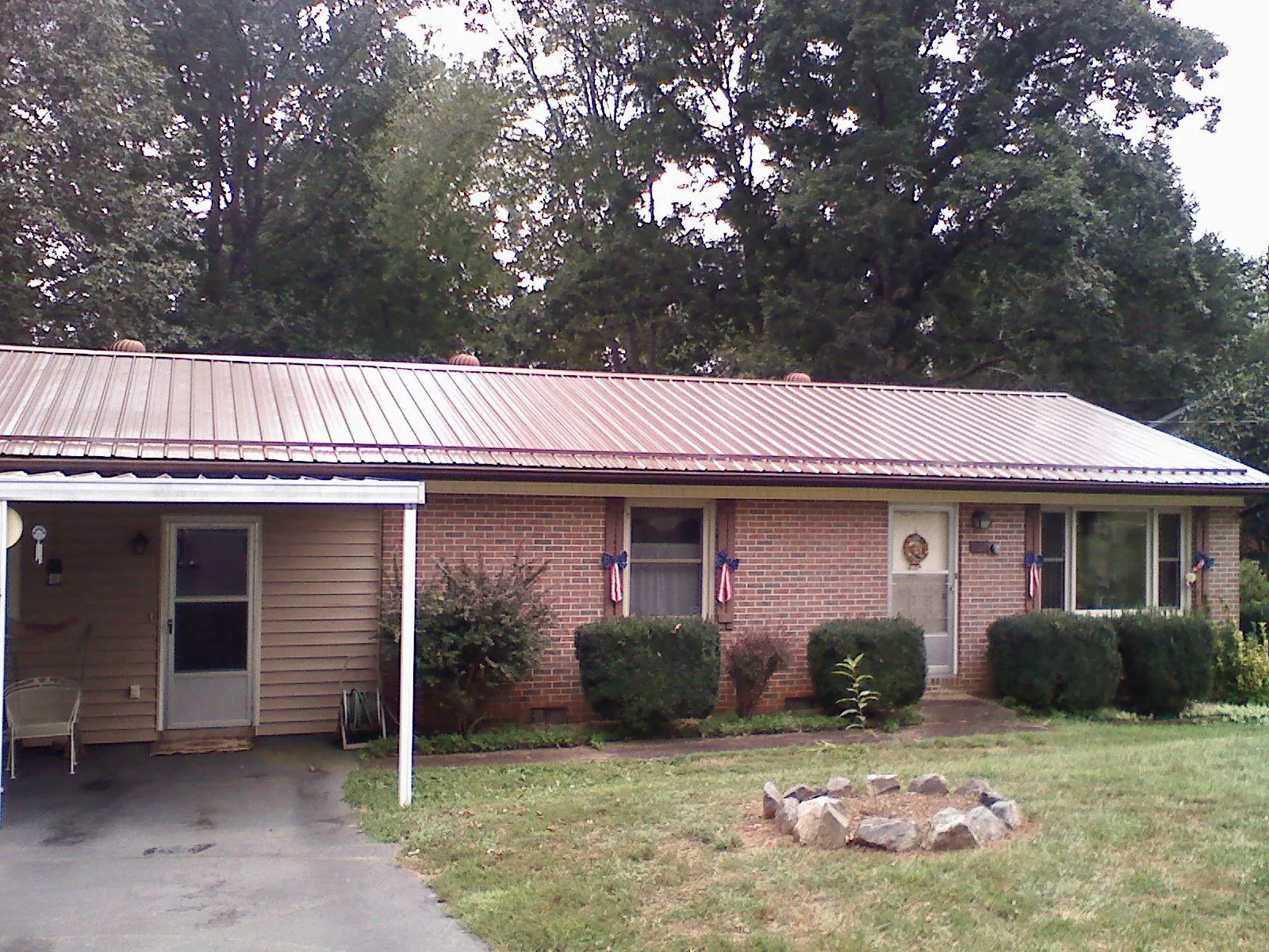 Bronze metal roof and carport on a brick ranch home — Roof Repair work by our crew in Almond